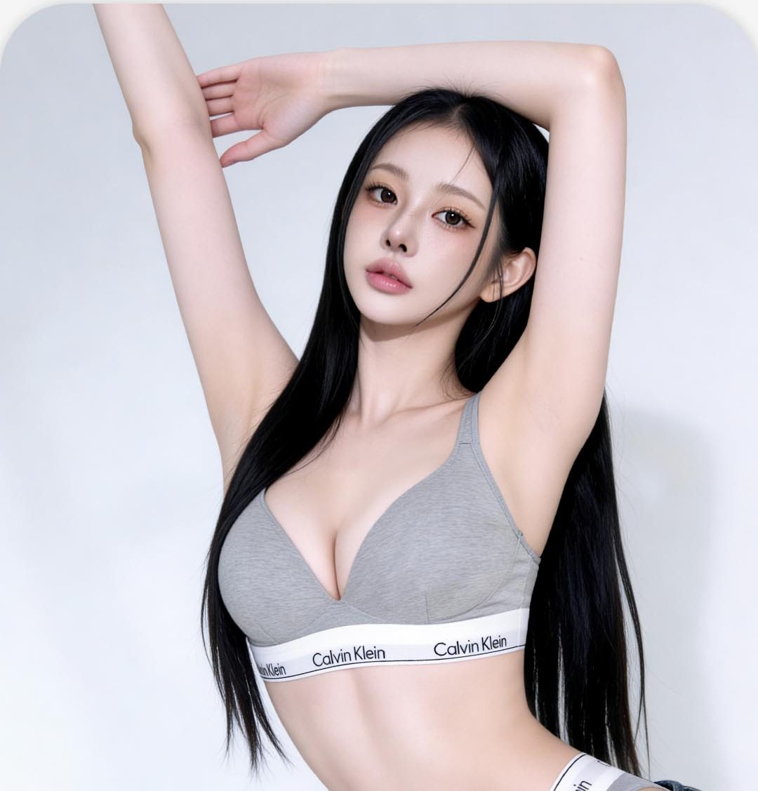 두 팔을 머리 위로 올린 회색 브라톱 여성 모델