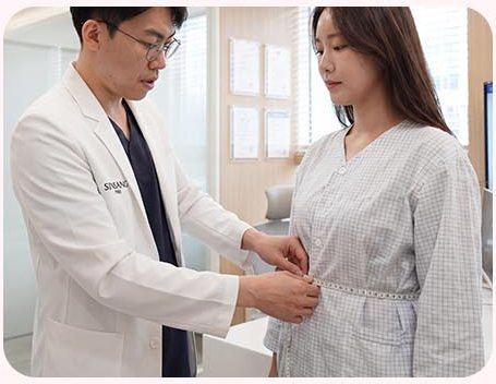 의료진이 환자복 차림 여성의 흉곽 둘레를 줄자로 재는 모습