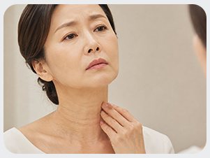 노화 — 목을 만지는 중년 여성