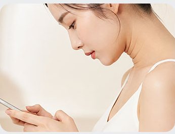 고개를 숙이고 휴대폰을 보는 여성
