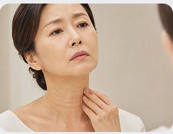 처진 목을 만지는 중년 여성